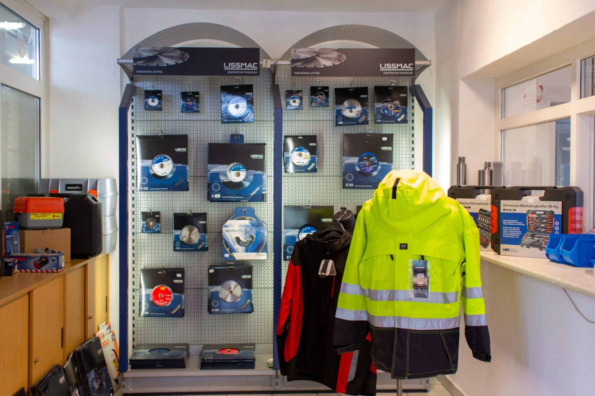 Gelbe Schutzkleidung und weitere Produkte in einem Verkaufsraum. 