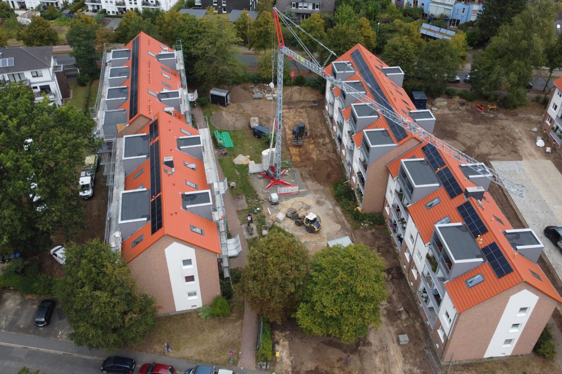 Luftaufnahme von einem Schnellmontagekran zwischen zwei Häuserblöcken. 