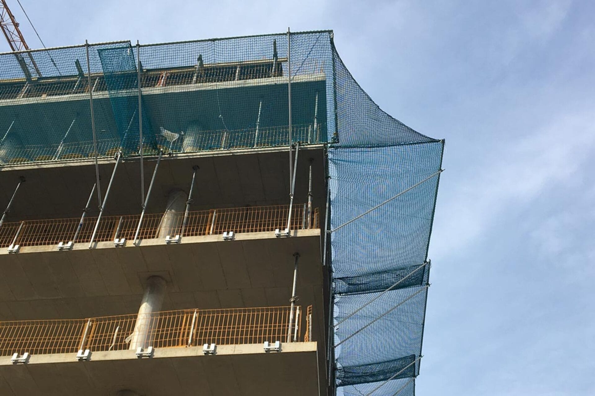 Materialauffangschirme Absturzsicherung: Ein Materialauffangschirm angebracht bei einem Hochhaus Bau